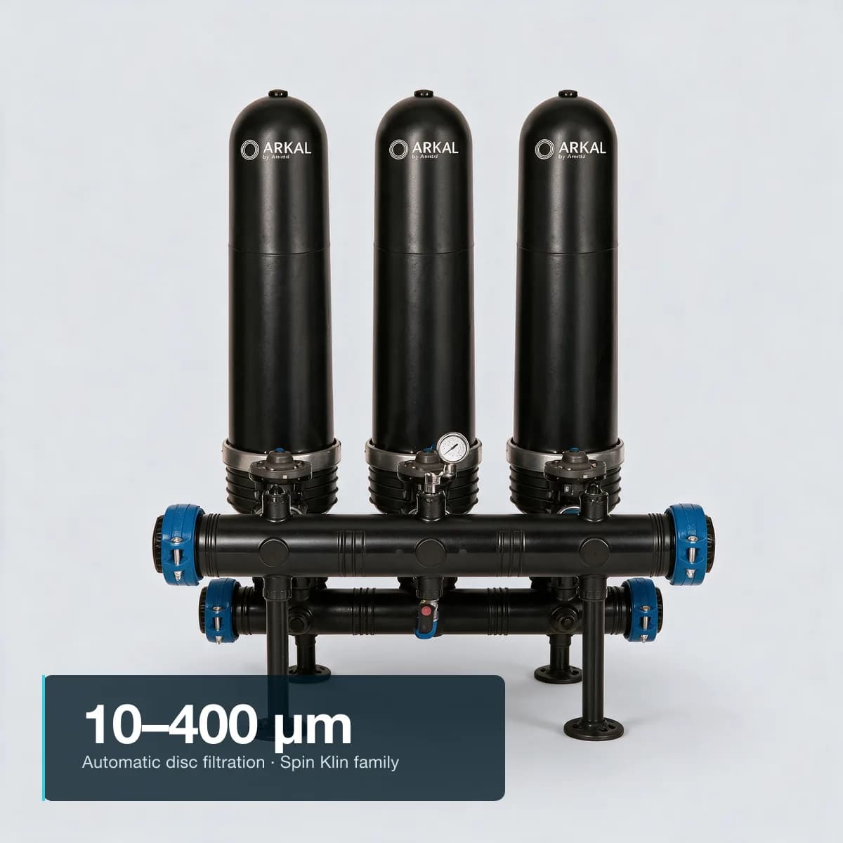 Studio render of an ARKAL by Amiad 2" Spin Klin industrial battery — three matte black polymeric housing units on a shared horizontal manifold with blue butterfly valves, short black support legs, pressure gauge. A compact editorial text block anchored to the bottom-left corner over the base/ground area carries the integrated headline 10–400 μm and the subtitle Automatic disc filtration · Spin Klin family.