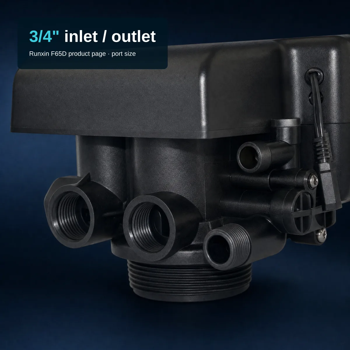 Close-up of the threaded side of a black polymer Runxin F65D valve: two large threaded ports side by side at the front, a smaller threaded stub and a small brine-line connector beside them, the round threaded base below and the plain black control head cover above, on a dark navy backdrop. Overlay text top-left over the cover: headline "3/4\" inlet / outlet", subtitle "Runxin F65D product page · port size".